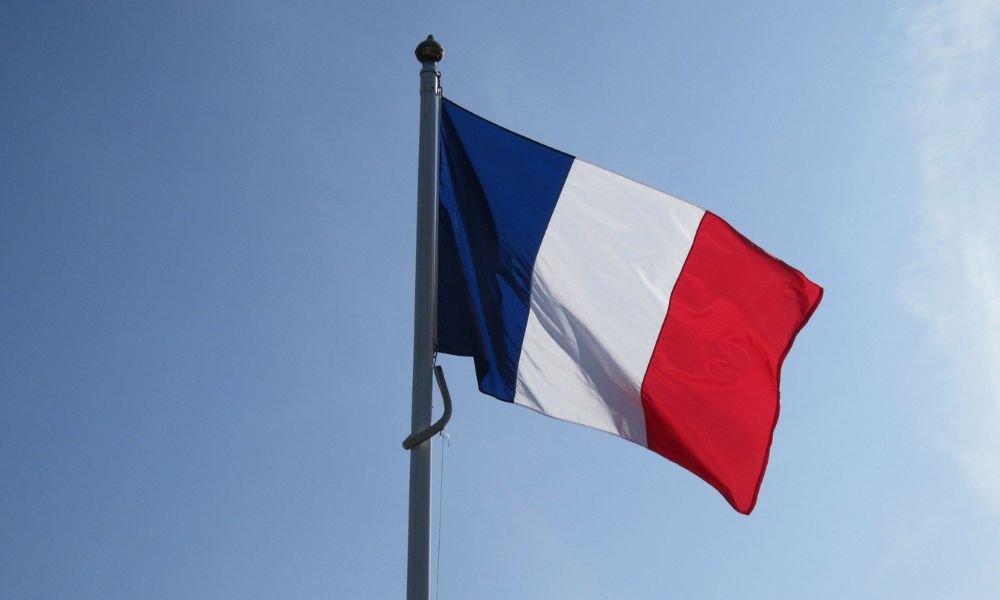 Foto de una bandera de Francia ondeando, utilizada para ilustrar el artículo "Impuesto de Sucesiones en Francia", escrito por Martínez Lafuente Abogados